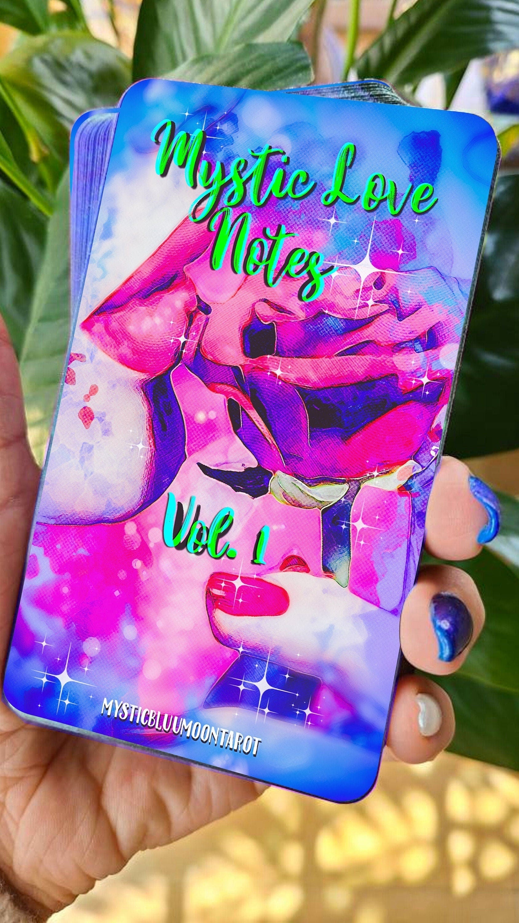 May include: A deck of cards with a blue background and a pink and purple illustration of lips. The text on the cards reads 'Mystic Love Notes Vol. 1' and 'MysticBlumoontarot'.